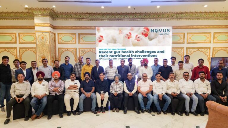 a large group of men posing for photo in front of a NOVUS slide at the gut health seminar